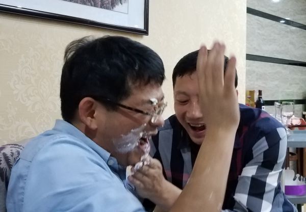 Xinhau a bit messy with the cake - and some help from a friend.