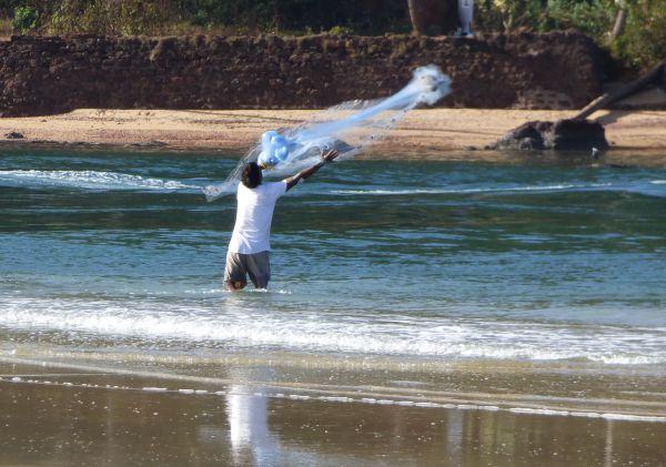 Although I couldn't catch the bird catching fish, I did manage to capture the human casting his net.